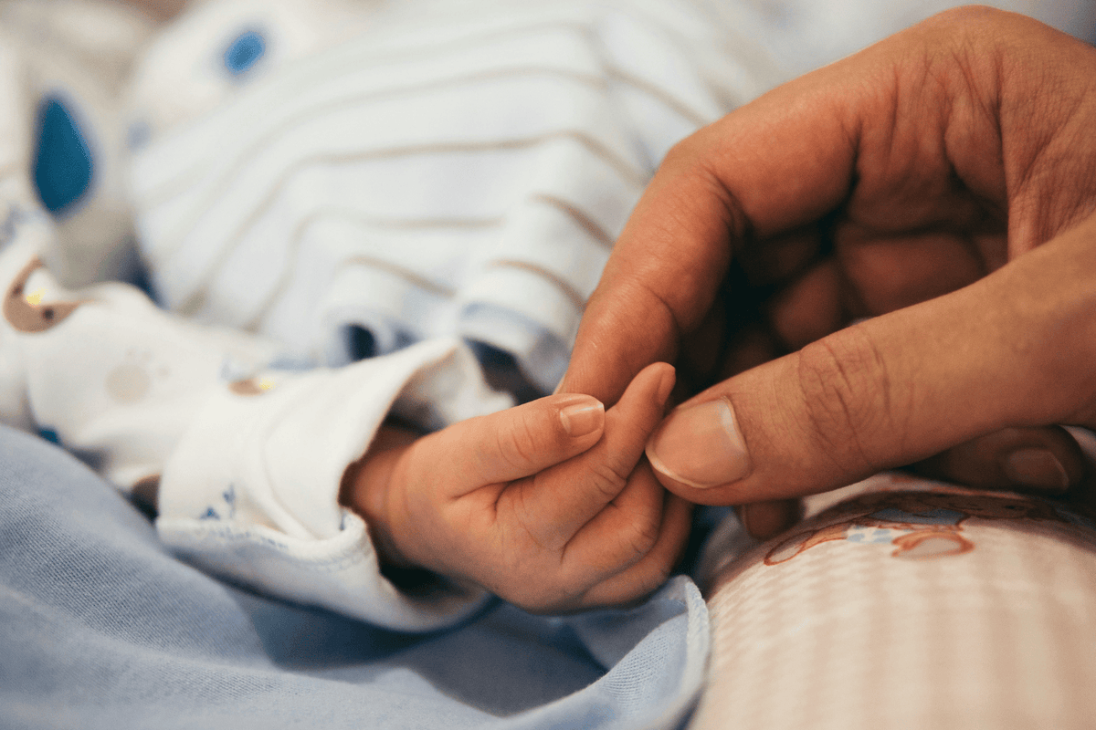 Mother holding baby hand