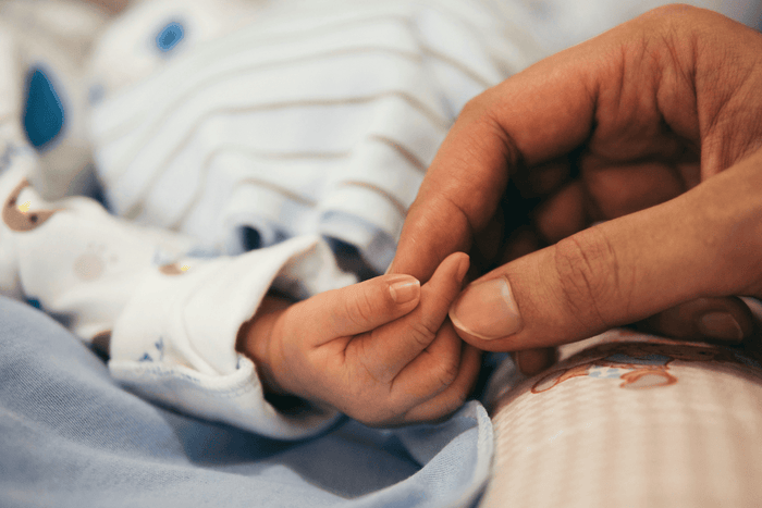 Mother holding baby hand